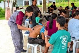 Freiwilligendienst im Ausland - Philippinen : 19+ Specials - Medizin & Gesundheitswesen Zwei Freiwillige hören auf den Philippinen die Lunge eines älteren Patienten im Public Health - Projekt ab.