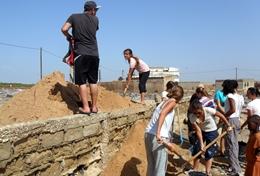 Projekte in Afrika - Senegal : Hausbau - Projekt Mit vereinten Kräften heben unsere Freiwilligen im Senegal eine Grube für ein neues Fundament aus, das die Grundsteine einer neuen Schule tragen soll.