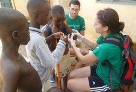 Projekte in Afrika - Togo : Medizin - Praktikum In einem Medical Outreach versorgt unsere Freiwillige einen jungen Patienten mit einer Platzwunde am Arm.