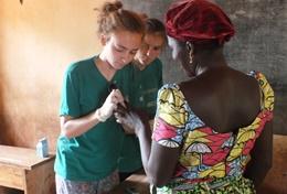 Projekte in Afrika - Togo : Medizin - Praktikum Eine Freiwillige ermittelt den Blutzuckerspiegel einer Dorfbewohnerin bei einem Check-up im Public Health - Praktikum in Togo.