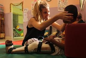 Physiotherapie - Praktikum im Ausland : Kambodscha Vorsichtig richtet eine Praktikantin die Haltung eines jungen Patienten im Physiotherapie - Praktikum in Kambodscha.