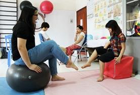 Physiotherapie - Praktikum im Ausland : Vietnam Im Therapieraum in einer physiotherapeutischen Praxis in Hanoi macht unsere Praktikantin eine Fußübung vor.