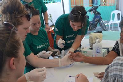 Auf einem „medical outreach“ messen unsere Freiwilligen den Blutzucker einer Patientin Sammle Praxiserfahrung in medizinischen Handgriffen im Medizin – Praktikum auf den Philippinen