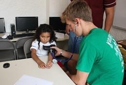 Medizin & Pflege : Mexiko Ein Schüler lernt im Schulferien - Special Public Health in Mexiko, wie man richtig den Blutdruck eines Patienten misst.