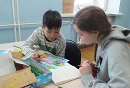 Praktikum im Ausland - die Mongolei : Schulferien - Specials - Sozialarbeit Eine Freiwillige hilft einem mongolischen Schüler mit den Hausaufgaben im Schulferien - Special Soziale Arbeit in der Mongolei.