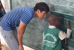 Projekte in Afrika - Senegal : Schulferien - Specials - Sozialarbeit Schreibübungen in der Vorschule: im Senegal übt ein Schüler zusammen mit einem Freiwilligen das Schreiben verschiedener Buchstaben.