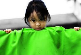 Freiwilligendienst im Ausland - Philippinen : Sozialarbeit Ein kleines Mädchen in der Kindertagesstätte in Cebu lugt für unsere Freiwillige im Sozialarbeits - Projekt in die Kamera.