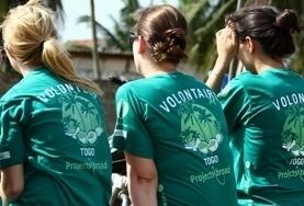 Sozialarbeit als Freiwilligendienst oder Praktikum im Ausland : Togo Freiwillige in Togo sitzen während eines Medical Outreaches für ihre Pause auf einer Bank und tauschen sich über ihre Erfahrungen mit den Patient/innen aus.