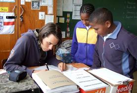 Freiwilligenarbeit in Afrika - Südafrika : Unterrichten Ein Freiwilliger korrigiert während seines Freiwilligendienstes in Südafrika die Hausaufgaben seiner Schulklasse.