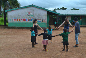 Projekte in Afrika - Ghana : Winter - Specials In unserer sozialen Partnereinrichtung in Ghana singen zwei Freiwillige zusammen mit den Kindern im Schulhof ein Lied.
